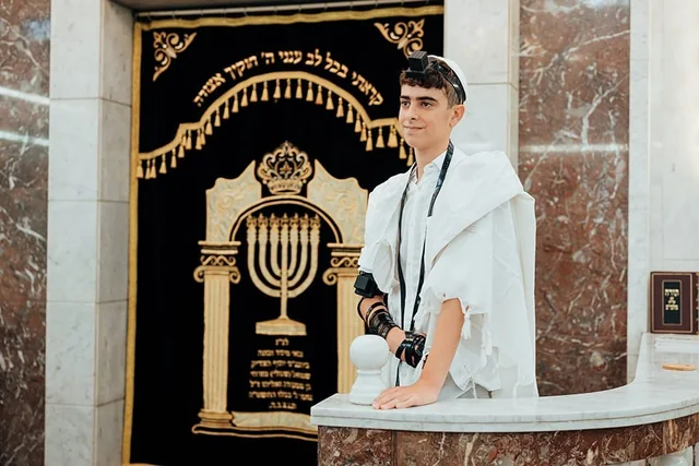 עילאי עטוף בטלית ליד ארון הקודש בעלייה לתורה
